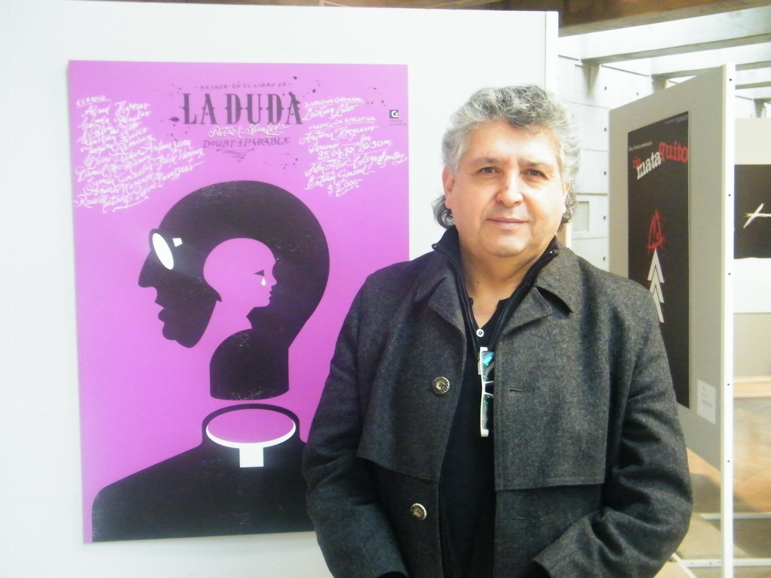 El profesor Julián Naranjo junto al afiche de la obra "La Duda", que ha generado variadas interpretaciones.