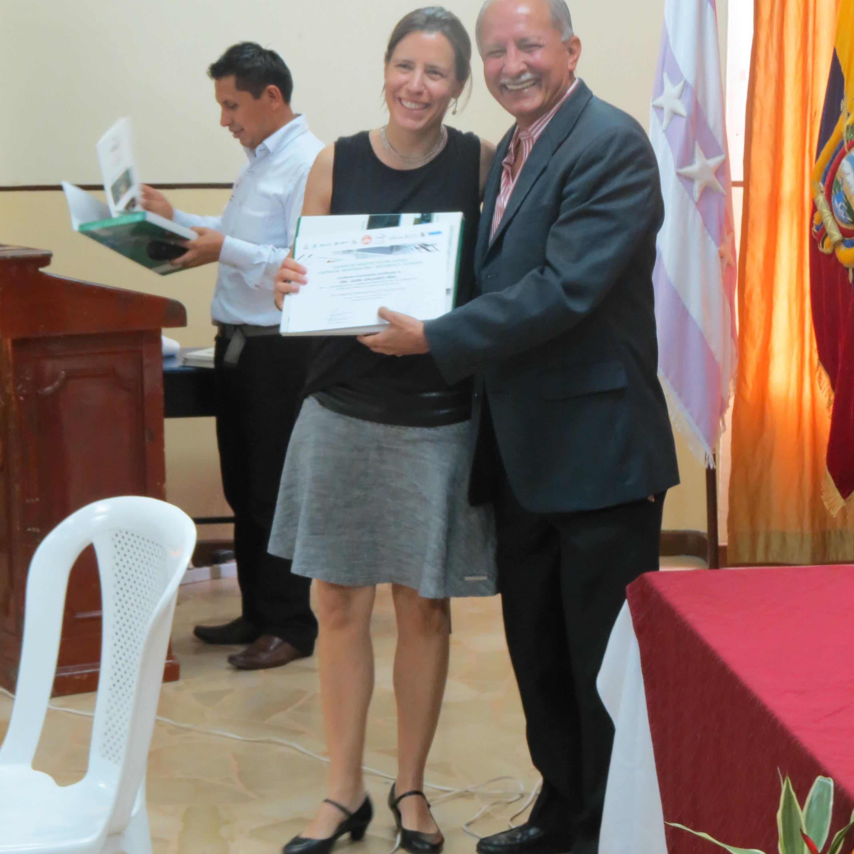 Profesora Laura Gallardo recibiendo diploma de reconocimiento.