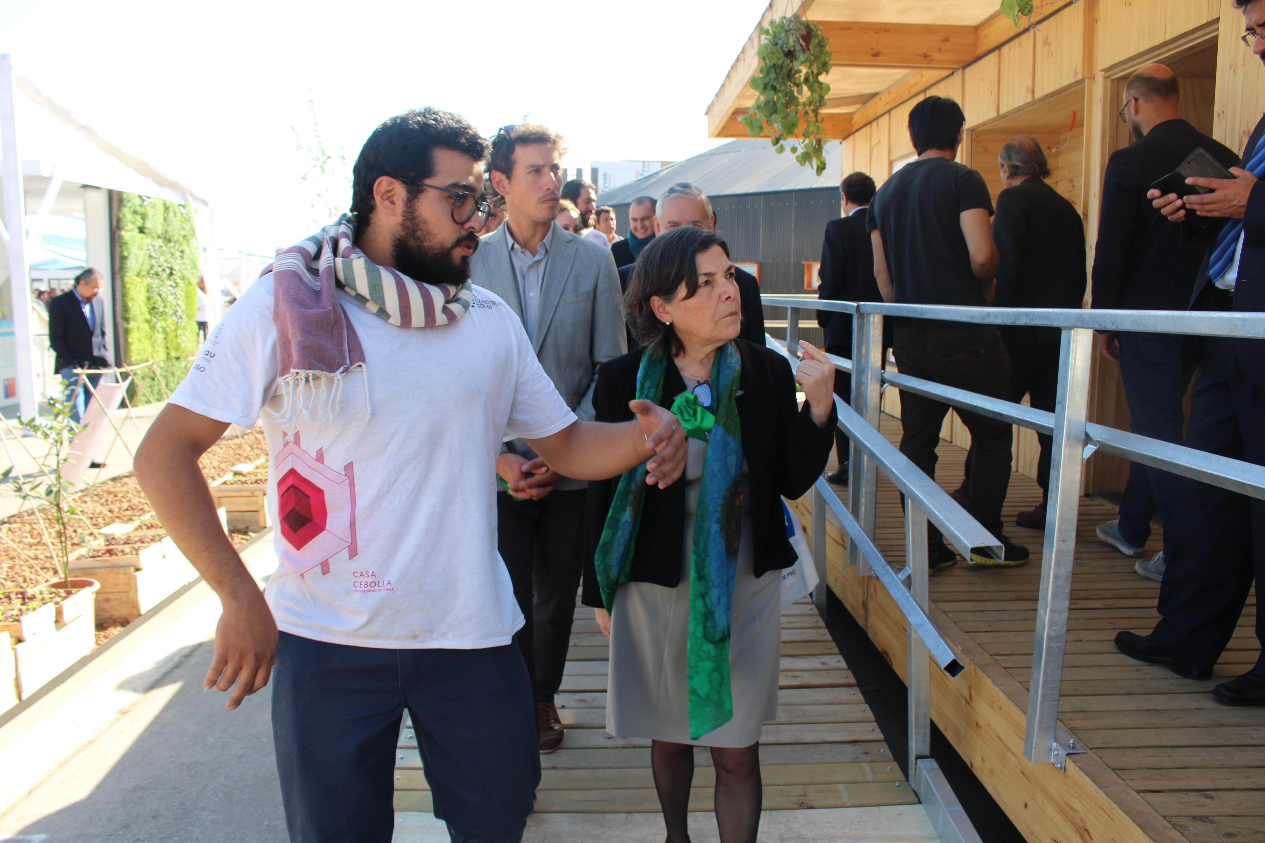 El estudiante Alastair Aguilera ofreció a la ministra Saball un recorrido al interior de la Casa Cebolla durante su exhibición en la Villa Solar.